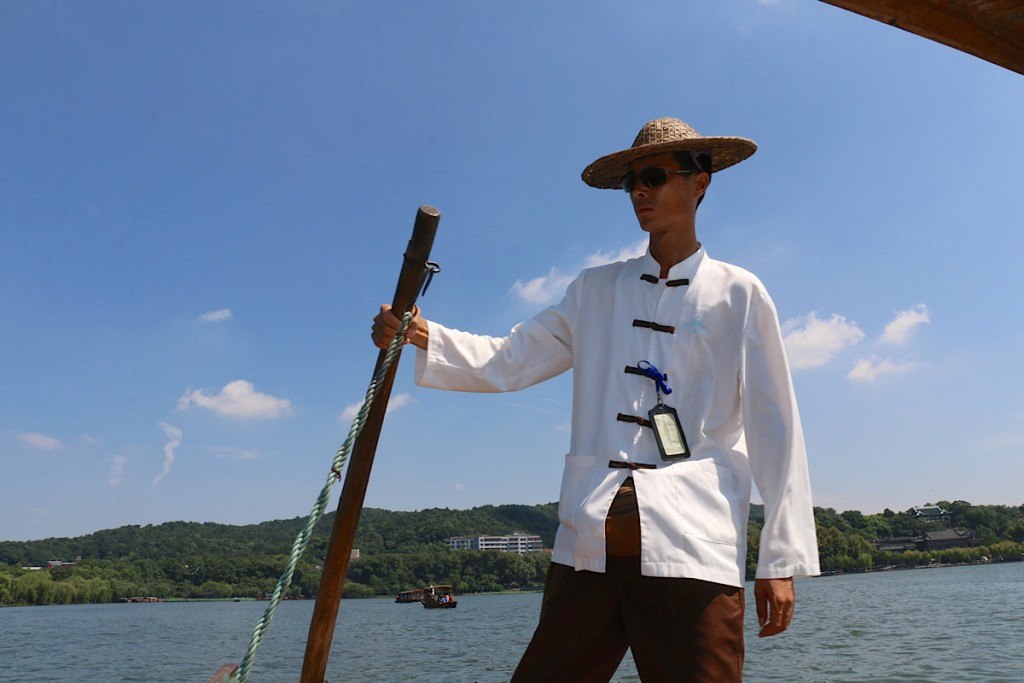 gondolier on West Lake in Hangzhou by MikesRoadTrip.com