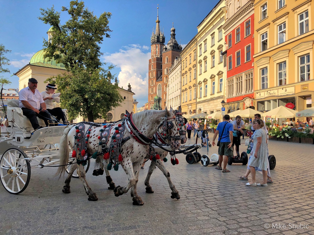 Krakow with horses in Old Town Square by MikesRoadTrip.com